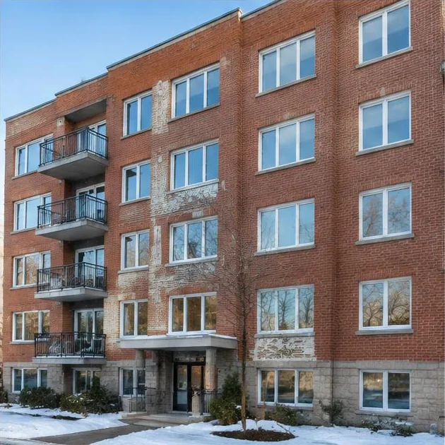 Façade d’un immeuble multilogement avec fenêtres alignées et vitrages de commerces au rez-de-chaussée